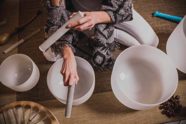 Adult woman playing singing crystal bowl stock photo