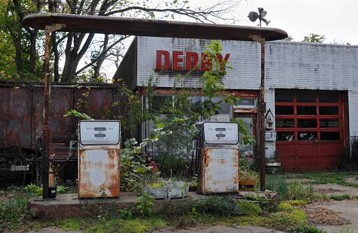 St. James, MO, USA, Oct. 3, 2019: Rusting gas pumps stand in front of an abandoned Derby service station and garage in the Route 66 city of St. James, Missouri.