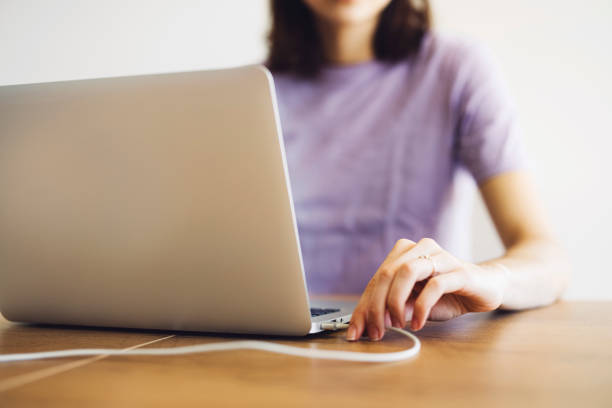 istock Woman hand plugging a charging cable in the laptop 1300876225