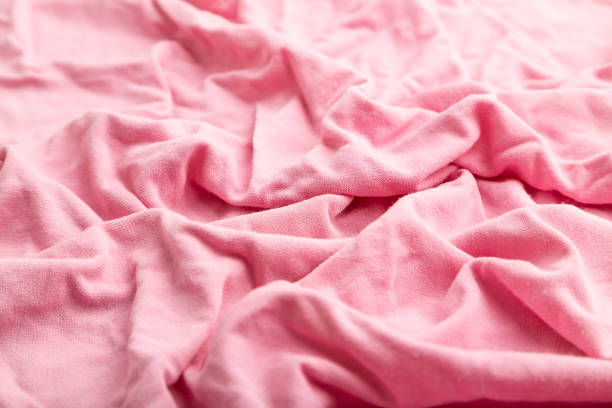 istock Fragment of pink cotton tissue. Side view, natural textile background and texture. wave concept, abstract. 1300876530