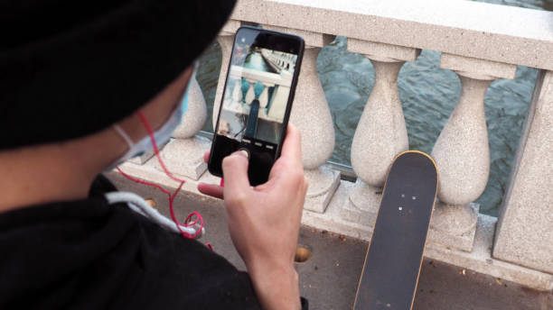 giovane pattinatore caucasico, che scatta foto con il suo smartphone nella città di lubiana. - alenka foto e immagini stock