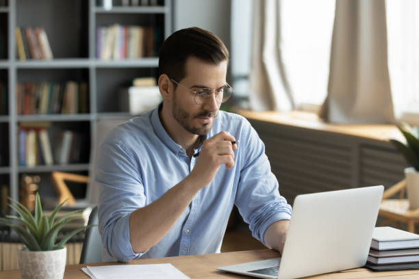 istock Concentrated young businessman working on computer at home office. 1300879255