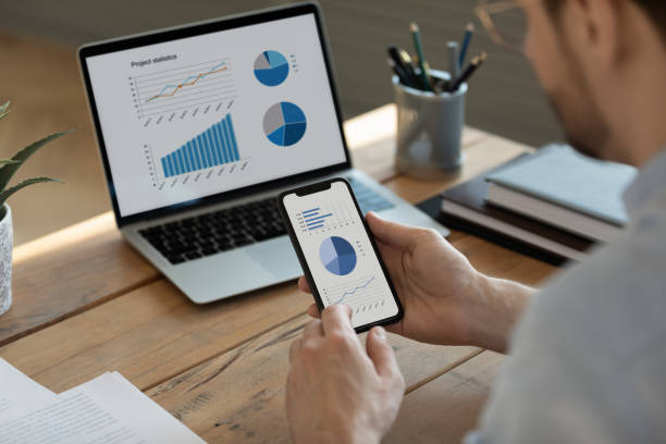 istock Focused young businessman analyzing marketing research results on gadgets. 1300879282