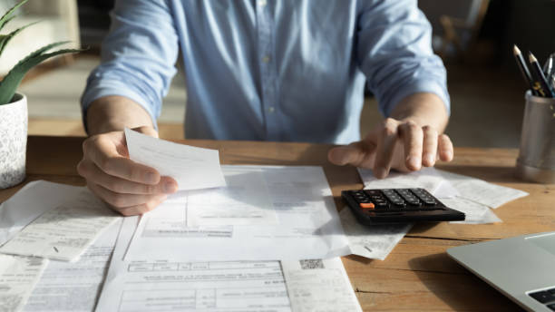 istock Young skilled man analyzing utilities household bills or taxes. 1300879285