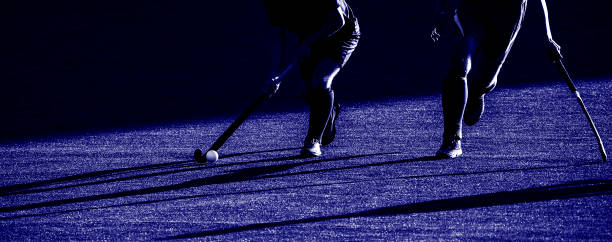 dos jugadores de hockey de campo, luchando por la pelota en el mediocampo durante un partido intenso sobre césped artificial. filtro de color azul - pass the ball fotografías e imágenes de stock