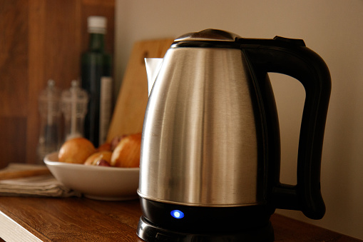 I tis a picture of an electric kettle with the power light on.