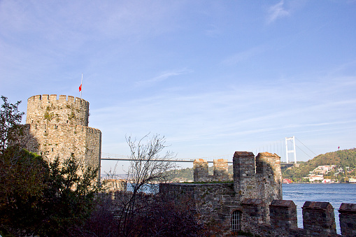 Istanbul, Turkey - November 10, 2019: People near the bosphorus in an sunny day. View from Rumeli Hisari was built by the Ottoman Sultan Mehmed II between 1451 and 1452, before his army's conquest of Constantinople.
