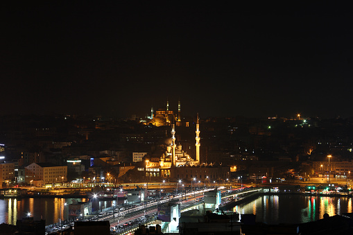 stanbul, Turkey - November 12, 2012: New mosque and hagia sophia view with galata bridge, reflection on goldenhorn in night view of istanbul.