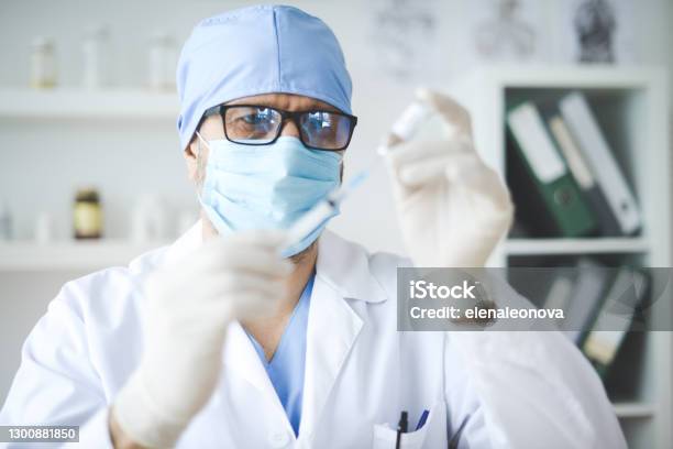 Doctor Holding A Bottle Of Covid19 Vaccine Stock Photo - Download Image Now - COVID-19 Vaccine, Adult, Adults Only