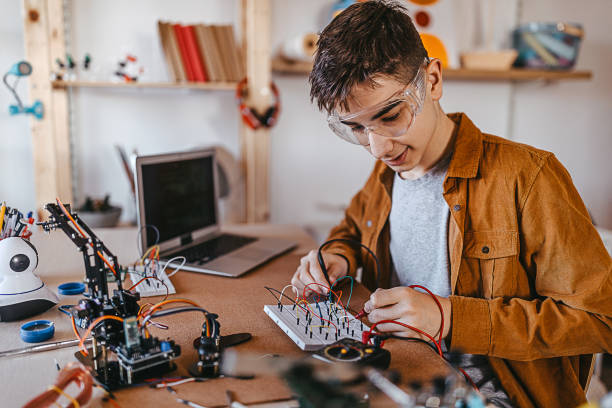 istock Teenager boy checking circuit board with multimeter 1300883619