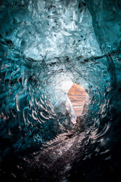 istock ice cave opening and mountains in backdrop 1300884284