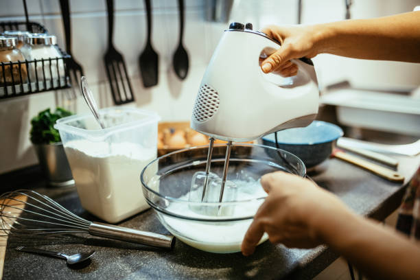 istock Woman using hand mixer or blender in kitchen 1300884342