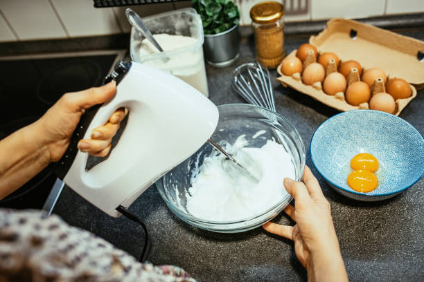 istock Woman using hand mixer or blender in kitchen 1300884344