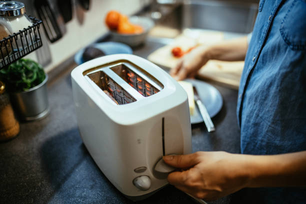 istock Woman using toaster to prepare sandwiches for breakfast 1300884621