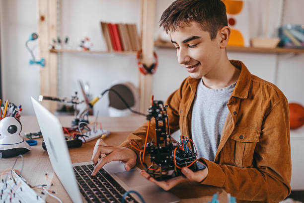 Teenage boy working on robotic arm project