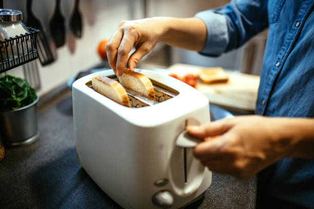 istock Unrecognizable woman using toaster to prepare sandwiches for breakfast during covid-19 lockdown 1300884702