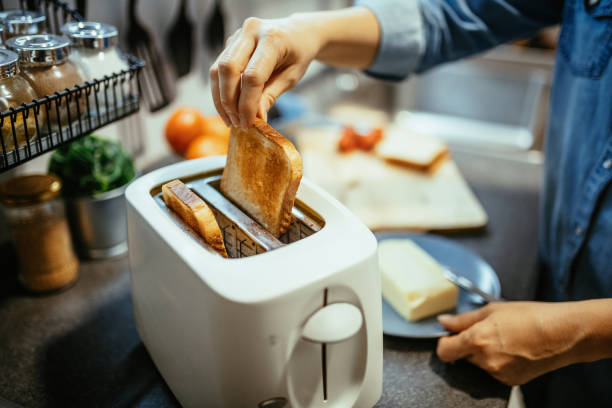 istock Woman using toaster to prepare sandwiches for breakfast 1300884869