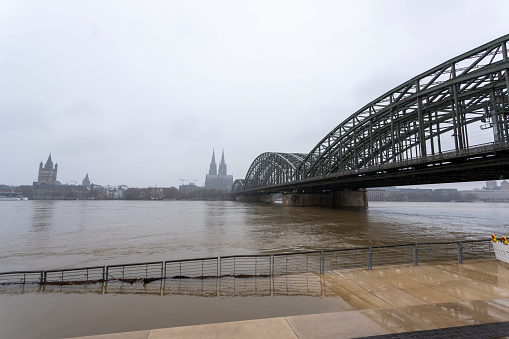 panorama of Cologne with cathedral and Hohenzollern bridge at snowy weather. Rhine river with high water