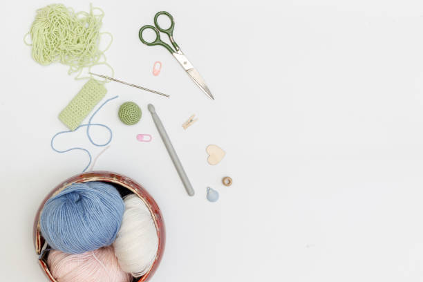istock Balls of pastel-colored Yarn in a ceramic bowl, objects and accessories for needlework on a white background. Top view with space 1300886984