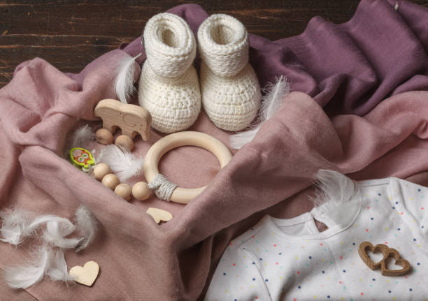 Gift hygge box for a newborn with rattles and toys made of natural wood, knitted boots. Eco-friendly gift set for the future baby stock photo