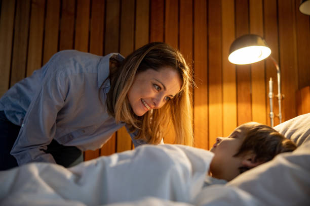 Mother Tucking Her Son To Bed