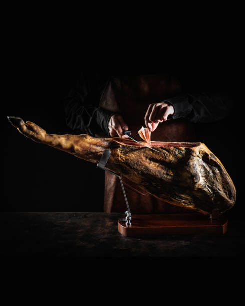 iberian ham serrano ham cutting slice male hands and knife on dark moody - animal fat imagens e fotografias de stock