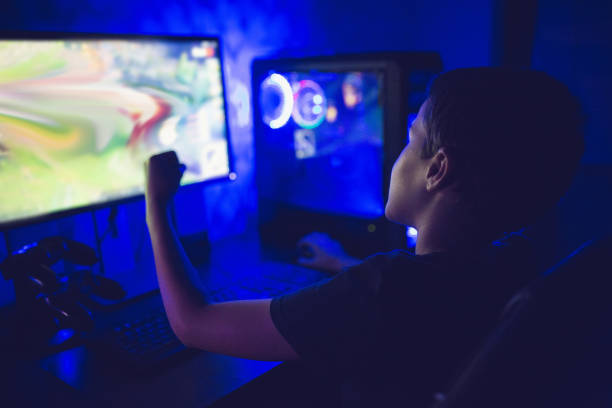 istock Modern gamer boy playing video games on his computer in his game room 1300889582