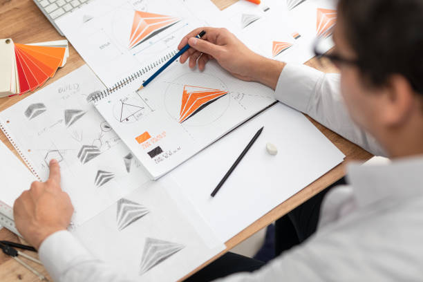 istock Graphic designer drawing sketches logo design. 1300889736