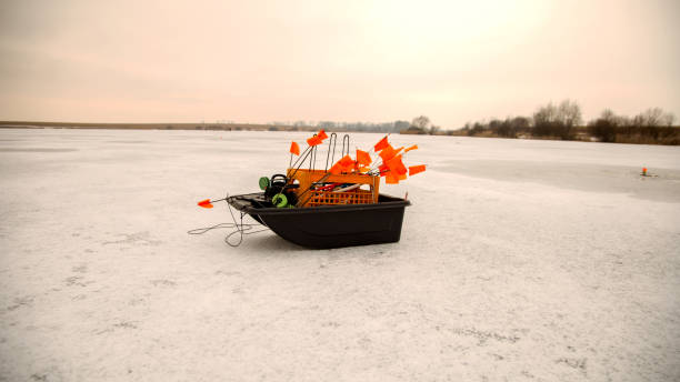 Winter pike fishing to simulate fish on a frozen lake. Small tackle for winter fishing on an ice pond. A set of tackle for winter fishing in the ice-hole installed tackle with a flag. pesca de lucio de invierno para simular peces en un lago congelado. pequeños aparejos para la pesca de invierno en un estanque de hielo. un conjunto de aparejos para la pesca de invierno en el agujero de hielo instalado tackle con una bandera.