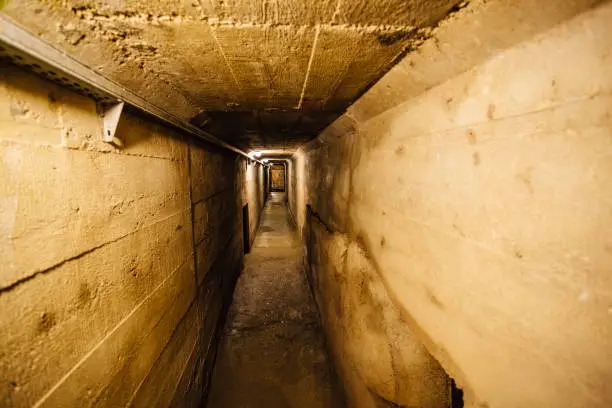 Dark creepy old corridor of underground bunker or prison.