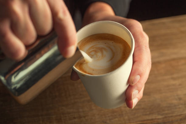Milk foam poured into a takeaway cup to form a cappuccino.