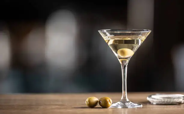 Photo of Dry Martini short drink cocktail with gin, dry vermouth and an olive garnish.