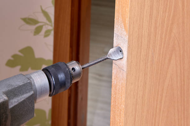istock Locksmith use flat bit to wood when drilling hole for latch. 1300894413