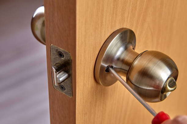 istock Carpenter fixes door knob with lock and latch on new door. 1300894417