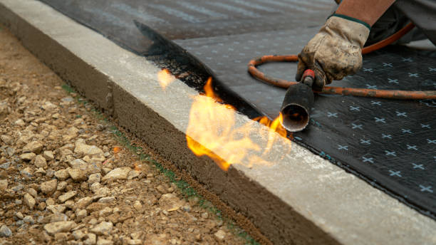 istock CLOSE UP: Contractor wielding a torch burns a roll of tar over the foundation. 1300895084