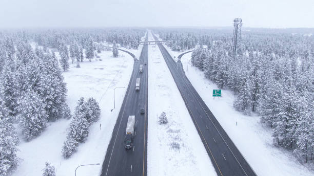istock DRONE: Trucks and cars drive along a wet interstate highway during a blizzard. 1300896185