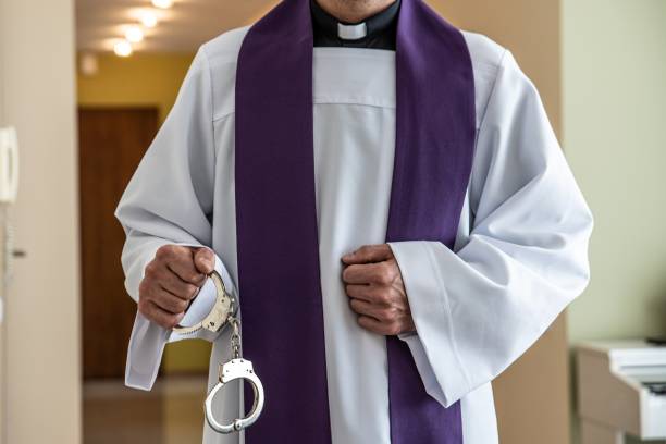 istock Catholic priest with handcuffs. Church and crime 1300896203
