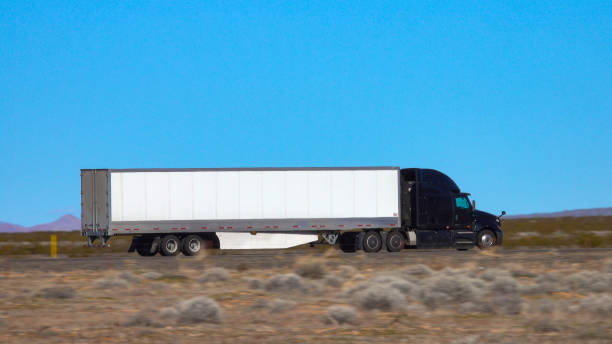istock CLOSE UP: Black truck speeds along the interstate highway crossing a desert 1300896225