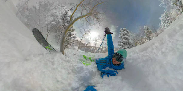 Free skier laughing while digging out after a soft crash into deep powder snow
