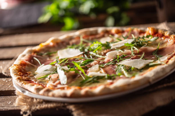 pizza italiana original con prosciutto, queso parmesano y hojas de cohete. - parma italia fotografías e imágenes de stock
