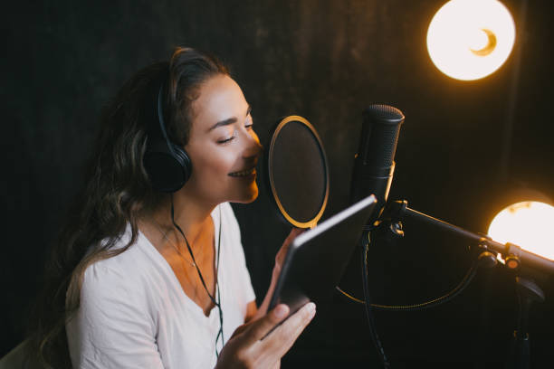 istock Young beautiful woman singing in microphone, recording voice in a studio. 1300897844