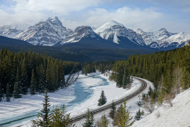 istock AERIAL: Flying above a snowy spruce forest covering valley under the mountains 1300898535