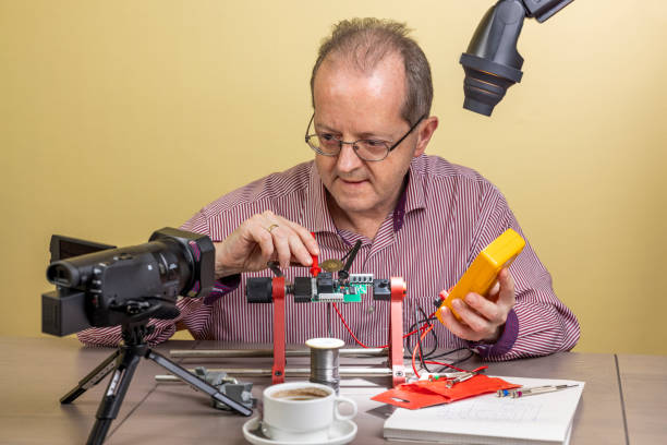 istock Measuring a voltage with a multimeter, a middle aged man is working from home, vlogging electronic repair instructions as side hustle for his social media followers on youtube 1300900603