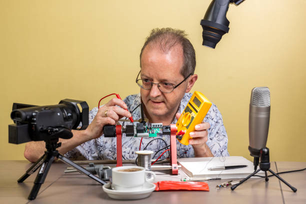 istock Showing a multimeter measurement to the camera, a middle aged man working from home, vlogging electronic repair instructions as side hustle for his social media followers 1300900831