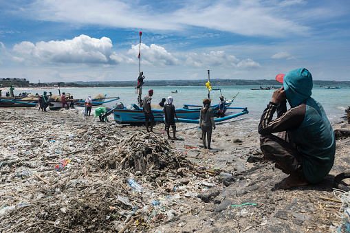 a group of people clean up trash on Jimbaran beach, Bali, December 9 2022