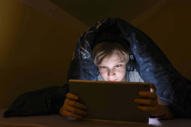 istock Little boy watching cartoons after bed time 1300905164