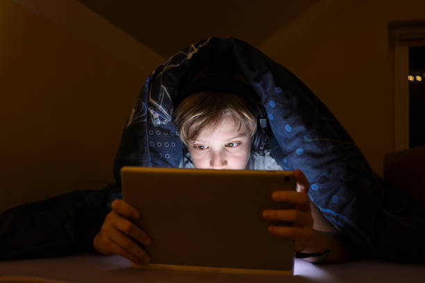 istock Little boy watching cartoons after bed time 1300905201