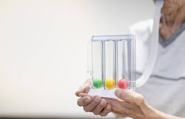 The old patient hand holding the Tri-ball incentive spirometry is medical equipment for post operation. stock photo