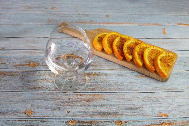 화이트 데킬라 또는 메즈칼 한 잔과 칠리 파우더를 곁들인 오렌지 슬라이스를 곁들인 테이블. - tequila reposado 뉴스 사진 이미지