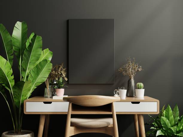 istock Mockup black frame on work table in living room interior on empty dark wall background. 1300910358